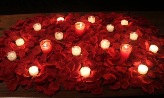 rose petals on bed with candles